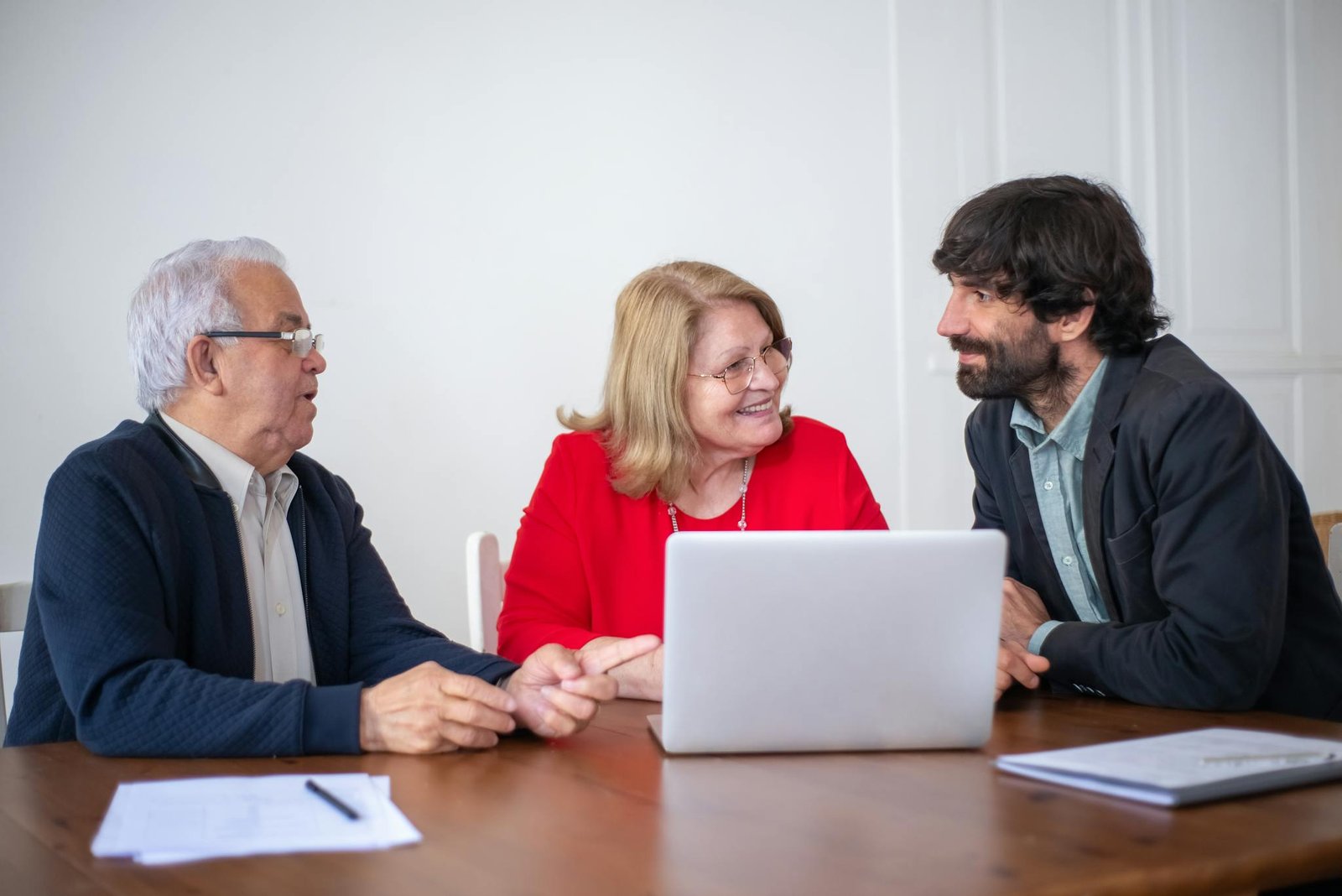 Elderly couple having a consultation with a professional advisor in a bright indoor setting.